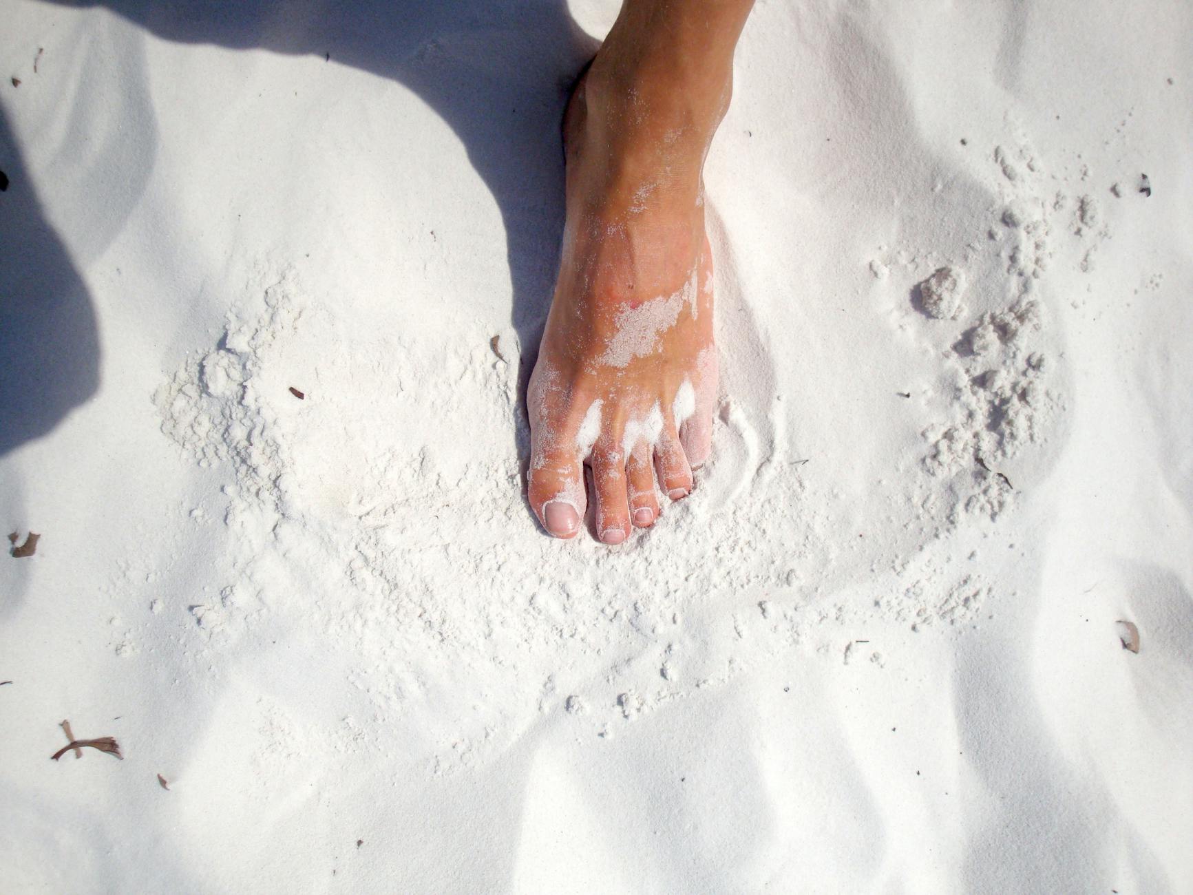 Foot on white sand, capturing the essence of a sunny Australian beach day.