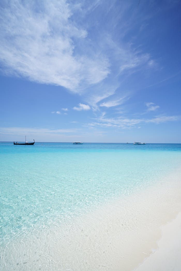 about-bg Peaceful beach scene with crystal clear waters and a deep blue sky, ideal for travel inspiration.