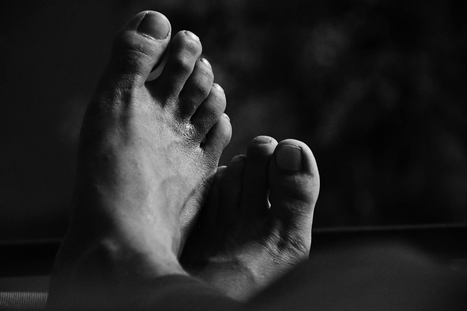 Monochrome close-up of bare feet in a relaxed pose. Artistic and calming.